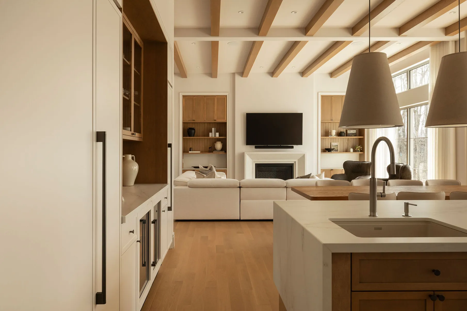 Cuisine avec salon et plafond de bois.
